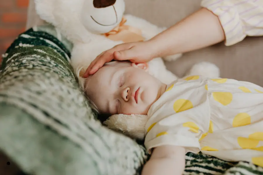 Bambina che dorme con orsacchiotto.- routine del sonno nei bambini